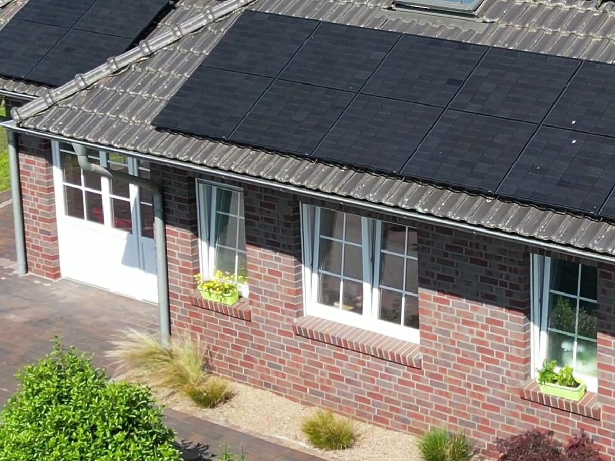 Photovoltaikanlage mit schwarzen Modulen auf einem Klinkerhaus